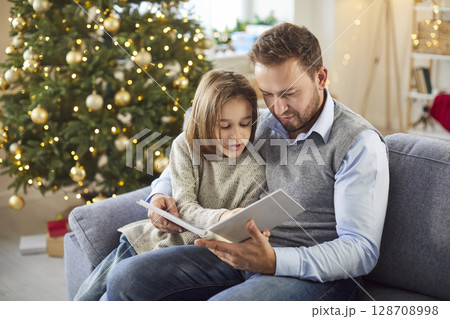 Father And Son Reading A Book Together At Home During Christmas Or New Year 128708998