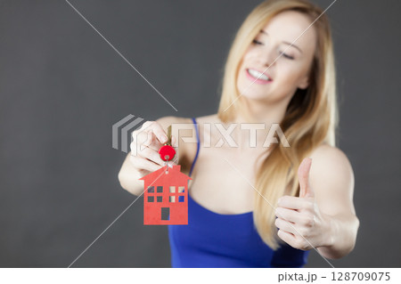 Woman holding key with house symbol 128709075
