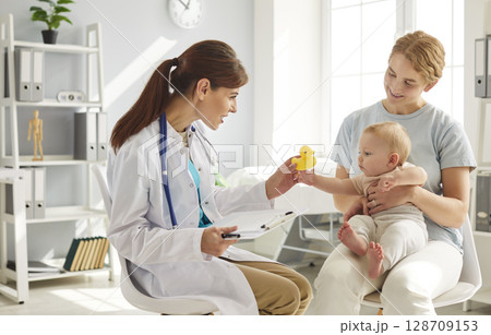 Pediatrician medical doctor treats newborn baby in clinic, monitoring child physical health Pediatrician medical doctor treats newborn baby in clinic, monitoring child physical health 128709153