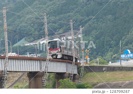 【広島・可部線】緑の山々を背に鉄橋を走るJR227系電車（Red Wing） 128709287