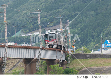 【広島・可部線】緑の山々を背に鉄橋を走るJR227系電車（Red Wing） 128709288