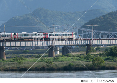 【広島・可部線】緑の山々を背に鉄橋を走るJR227系電車(Red Wing) 【広島・可部線】緑の山々を背に鉄橋を走るJR227系電車(Red Wing) 128709290