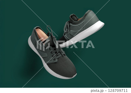 Modern Green Running Sneakers with White Soles on Green Background Modern Green Running Sneakers with White Soles on Green Background 128709711
