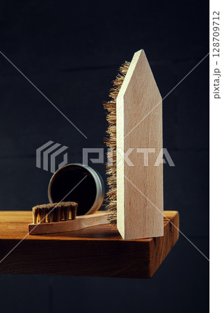 Wooden Shoe Brushes and Polish on Dark Background 128709712