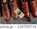 Premium Leather Shoes with Quality Tag on Wooden Shelf 128709714