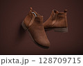Stylish Brown Suede Chelsea Boots on Monochromatic Background 128709715