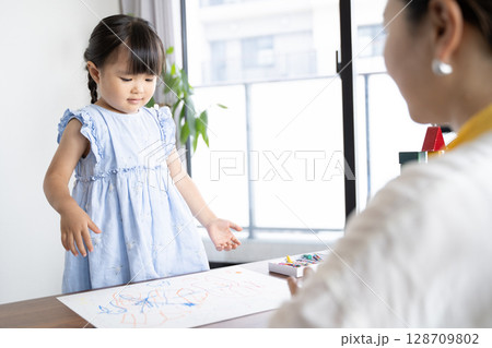 クレヨンでお絵描きを楽しむ女の子の知育シーン 128709802