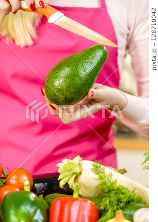 Woman cutting avocado 128710042