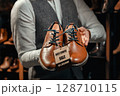 Salesman Holding Brown Leather Shoes with Discount Tag 128710115