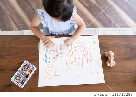 クレヨンでお絵描きを楽しむ女の子の知育シーン俯瞰 128710283