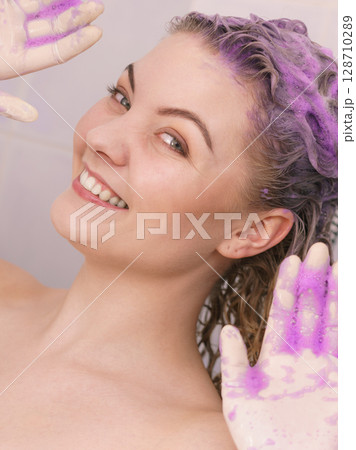 Woman applying toner shampoo on her hair Woman applying toner shampoo on her hair 128710289