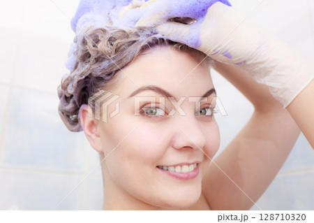 Woman applying toner shampoo on her hair 128710320