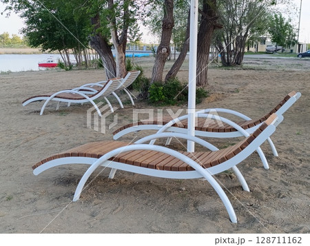Sunbeds on a sandy beach. Central beach in Kostanay. 128711162