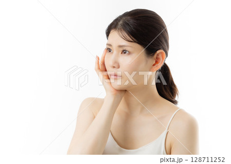 肌の悩みを気にする若い女性の表情（白背景） 128711252