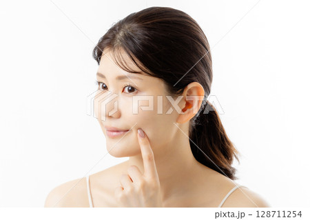 肌の悩みを気にする若い女性の表情(白背景) 肌の悩みを気にする若い女性の表情(白背景) 128711254