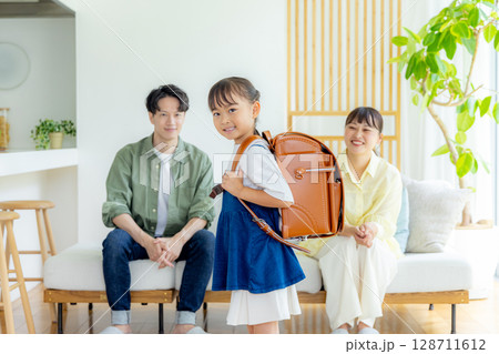 ランドセルを背負っている女の子　見守る両親 128711612