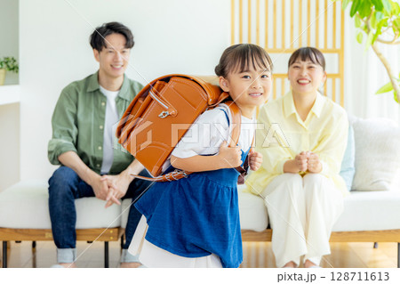 ランドセルを背負っている女の子　見守る両親 128711613