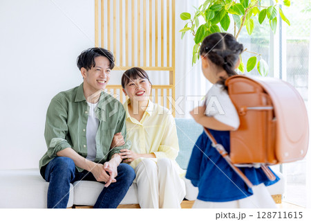 ランドセルを背負っている女の子 見守る両親 ランドセルを背負っている女の子 見守る両親 128711615