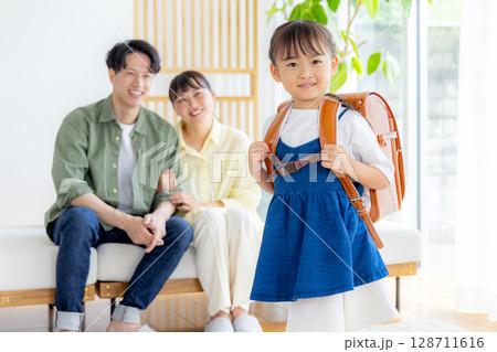 ランドセルを背負っている女の子 見守る両親 ランドセルを背負っている女の子 見守る両親 128711616