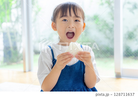 おにぎりを食べる女の子 おにぎりを食べる女の子 128711637