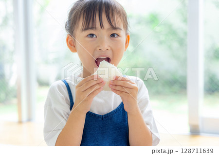 おにぎりを食べる女の子 128711639