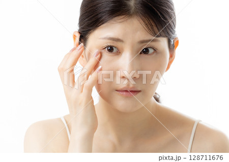 目元の悩みを気にする若い女性（白背景） 128711676