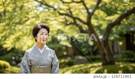Elegant senior japanese woman in a traditional kimono smiling serenely in a lush green garden Elegant senior japanese woman in a traditional kimono smiling serenely in a lush green garden 128711901