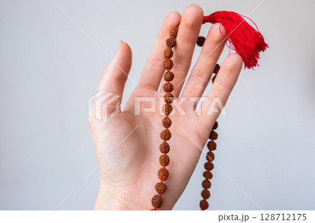 Japamala on the hand. Prayer beads. Religious equipment 128712175