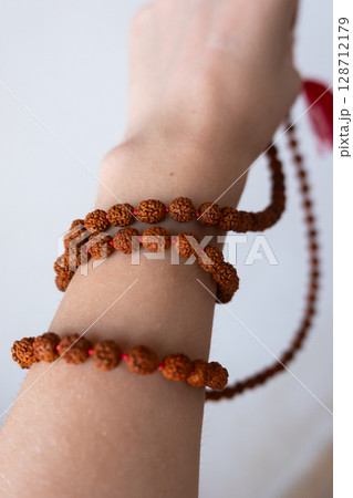 Japamala on the hand. Prayer beads. Religious equipment 128712179