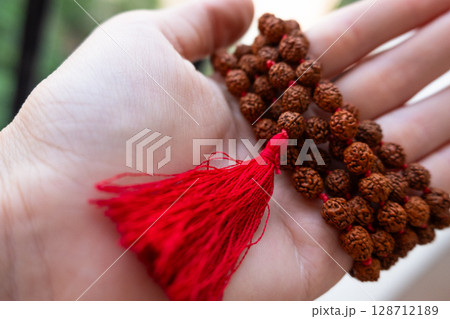Japamala on the hand. Prayer beads. Religious equipment 128712189