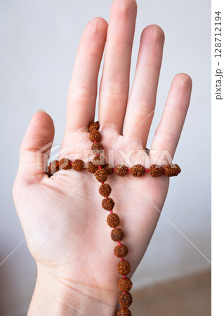 Japamala on the hand. Prayer beads. Religious equipment Japamala on the hand. Prayer beads. Religious equipment 128712194