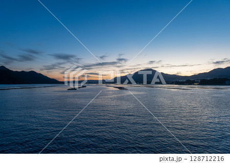 夕暮れに染まる瀬戸内海と牡蠣いかだの風景（広島・宮島） 128712216