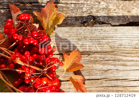 Red berries of viburnum on rustic wooden background. Top view, copy space 128712419