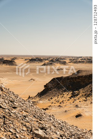 Ash-covered hills in Egypt's Black Desert under a clear sky, scenic and remote landscape. Volcanic	 128712493