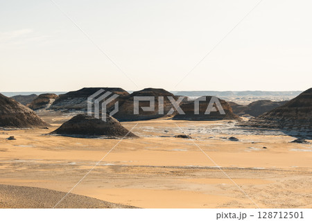 Ash-covered hills in Egypt's Black Desert under a clear sky, scenic and remote landscape. Volcanic	 128712501