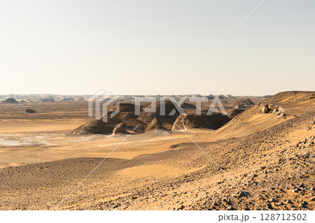 Ash-covered hills in Egypt's Black Desert under a clear sky, scenic and remote landscape. Volcanic	 128712502