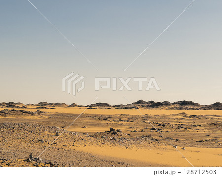 Ash-covered hills in Egypt's Black Desert under a clear sky, scenic and remote landscape. Volcanic	 128712503