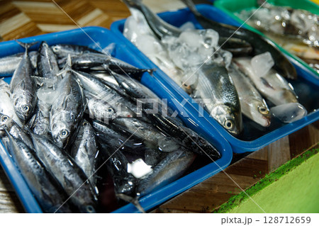 Asian fish market, fresh seafood assortment with various types of fish on trays 128712659