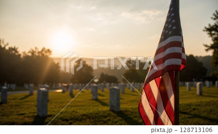 Beautiful Sunset Over Cemetery with American Flag Waves in Gentle Breeze and Peaceful Atmosphere 128713106