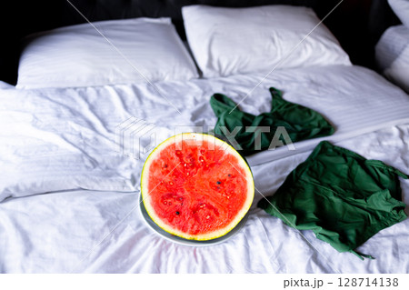 Fresh watermelon on a plate with green clothing on white bedding Fresh watermelon on a plate with green clothing on white bedding 128714138