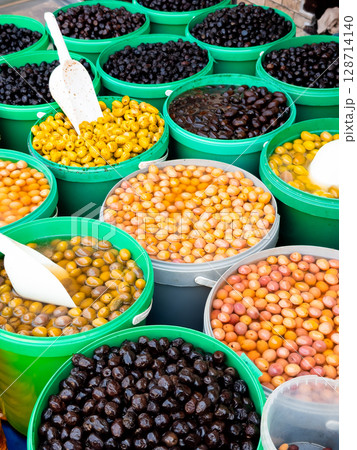 Assorted olives in various container sizes at market display 128714140