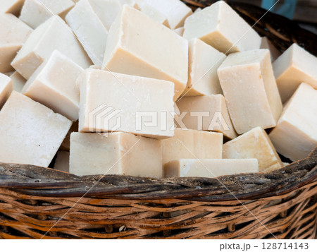 Blocks of handmade natural soap in a wicker basket 128714143