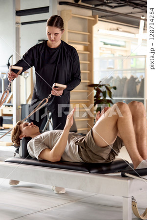 Personal training session with a focus on exercises using equipment for fitness Personal training session with a focus on exercises using equipment for fitness 128714284