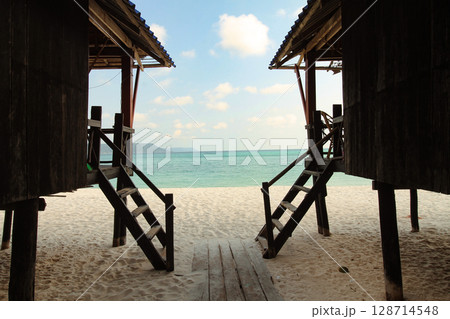 A view of the ocean framed by bungalows that capturing a candid tranquil seaside atmosphere and island life at Koh Rong Sanloem, Sihanoukville, Cambodia 128714548