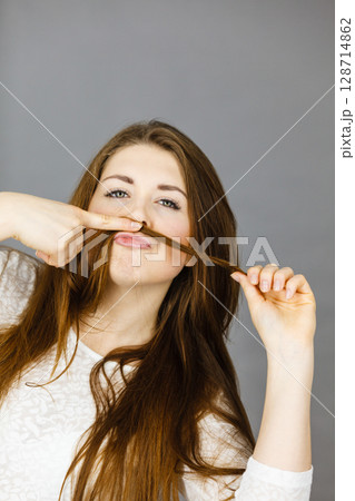 Woman having fun with her hair making moustache 128714862