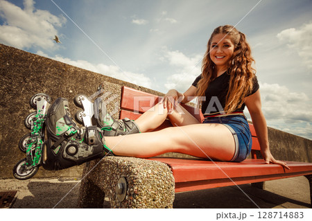 Young woman riding roller skates 128714883