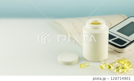 Mockup of natural vitamins or supplements, cardiogram and tonometer on doctor desk with copy space. White bottle with healthy supplements in gel capsules. Omega 3. Vitamins and nutrients for heart Mockup of natural vitamins or supplements, cardiogram and tonometer on doctor desk with copy space. White bottle with healthy supplements in gel capsules. Omega 3. Vitamins and nutrients for heart 128714901