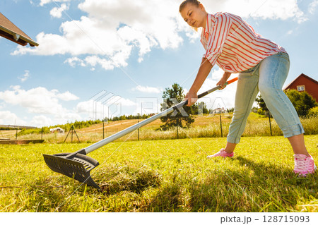 Woman raking leaves Woman raking leaves 128715093