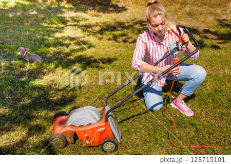 Woman mowing green grass Woman mowing green grass 128715101