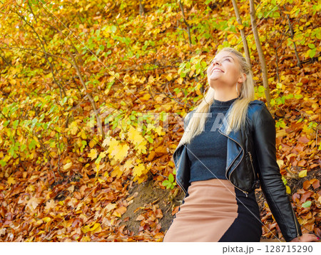 Fashion woman relaxing in autumn park 128715290